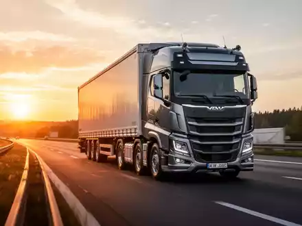 Ein moderner Lkw fährt bei Sonnenuntergang auf einer Autobahn, symbolisch für die aktuelle logistische Debatte. - Foto: über boerse-global.de