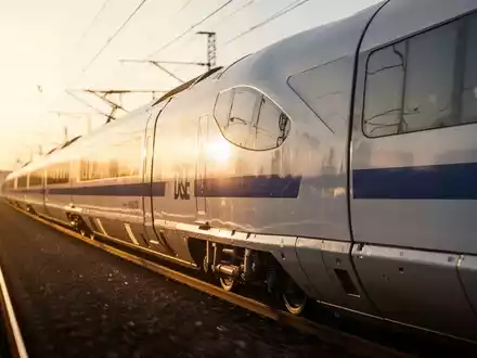 Moderner ICE-Schnellzug auf Gleisen während der goldenen Stunde. - Foto: über boerse-global.de