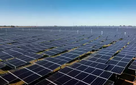 Moderne Solarpark-Anlage mit zahlreichen Photovoltaik-Modulen unter strahlend blauem Himmel. - Foto: über boerse-global.de