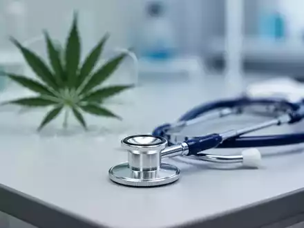 Stethoskop auf einem Labortisch neben einer symbolischen Darstellung von Cannabis für medizinische Zwecke. - Foto: über boerse-global.de