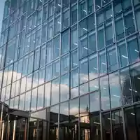 Moderne Glasfassade eines Bürogebäudes in Berlin unter blauem Himmel als Symbol für Finanzpolitik. - Foto: über boerse-global.de