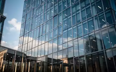 Moderne Glasfassade eines Bürogebäudes in Berlin unter blauem Himmel als Symbol für Finanzpolitik. - Foto: über boerse-global.de