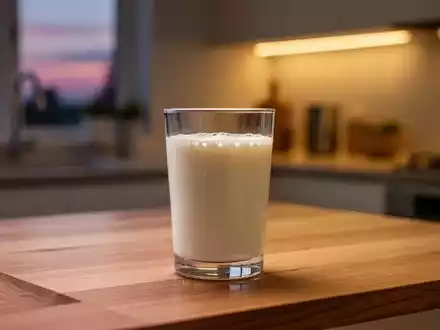 Ein Glas frischer Kefir auf einem Holztisch bei Dämmerlicht, Fokus auf die Textur des Getränks. - Foto: über boerse-global.de