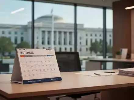 Ein Schreibtisch mit einem Kalender vor einem unscharfen Hintergrund eines Bürogebäudes im öffentlichen Dienst. - Foto: über boerse-global.de