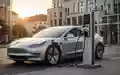 Modernes Elektroauto an einer öffentlichen Ladestation in einer deutschen Stadt bei Sonnenuntergang. - Foto: über boerse-global.de