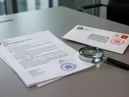 Ein offizielles Dokument und ein Briefumschlag auf einem Schreibtisch als Symbol für rechtliche Zustellungen. - Foto: über boerse-global.de