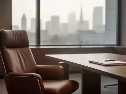 Ein minimalistisches, lichtdurchflutetes Büro eines Politikers mit einem leeren Schreibtisch und einem Sessel. - Foto: über boerse-global.de