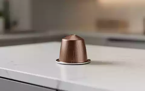 Eine einzelne Kaffeekapsel auf einer modernen Oberfläche, die Nachhaltigkeit und neue Verpackungsrichtlinien symbolisiert. - Foto: über boerse-global.de