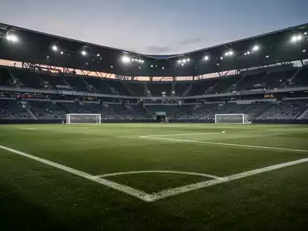 Ein gepflegtes Fußballstadion bei Dämmerung, das die professionelle Atmosphäre des Sportmanagements widerspiegelt. - Foto: über boerse-global.de