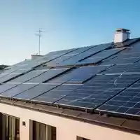 Moderne Solaranlagen auf einem Hausdach unter blauem Himmel als Symbol für die Energiewende und Netzentgelte. - Foto: über boerse-global.de