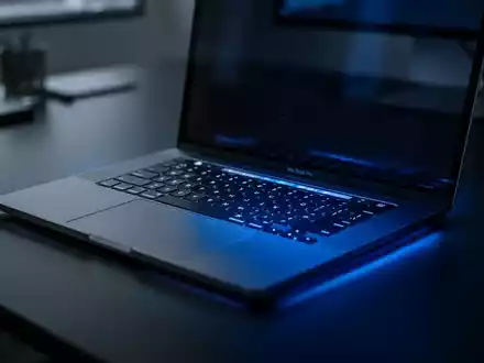 Ein Apple MacBook Pro auf einem dunklen Schreibtisch bei gedimmter, bläulicher Beleuchtung. - Foto: über boerse-global.de