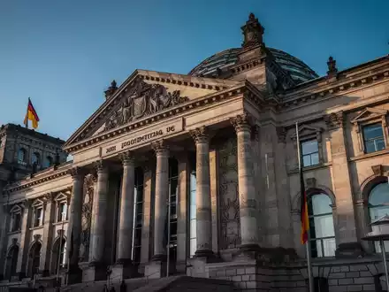 Das Gebäude des Deutschen Bundestages unter blauem Himmel, Fokus auf die Architektur des Reichstagsgebäudes. - Foto: über boerse-global.de