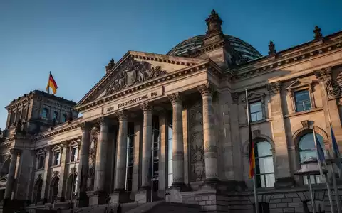 Das Gebäude des Deutschen Bundestages unter blauem Himmel, Fokus auf die Architektur des Reichstagsgebäudes. - Foto: über boerse-global.de