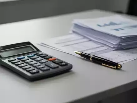 Ein Schreibtisch mit einem Taschenrechner und Unterlagen, die finanzielle Belastungen und sinkende Nettolöhne symbolisieren. - Foto: über boerse-global.de