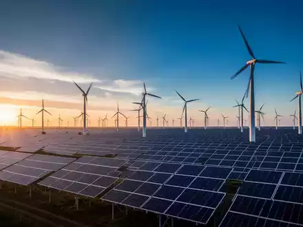 Moderne Windkraftanlagen und Solarparks in einer weitläufigen Landschaft bei Sonnenuntergang als Symbol der Energiewende. - Foto: über boerse-global.de
