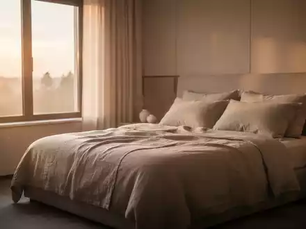 Ein friedliches, modern eingerichtetes Schlafzimmer bei Tagesanbruch mit sanftem Morgenlicht, das eine ruhige Atmosphäre vermittelt. - Foto: über boerse-global.de