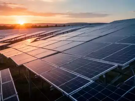 Reihen von Solarmodulen in einem Solarpark bei Sonnenuntergang als Symbol für Erneuerbare-Energien-Projekte. - Foto: über boerse-global.de