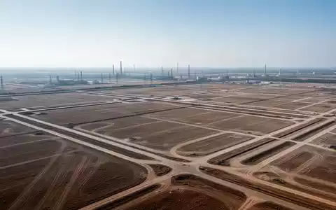 Weitläufiges, unbebautes Industriegelände bei klarem Tageslicht aus der Vogelperspektive. - Foto: über boerse-global.de