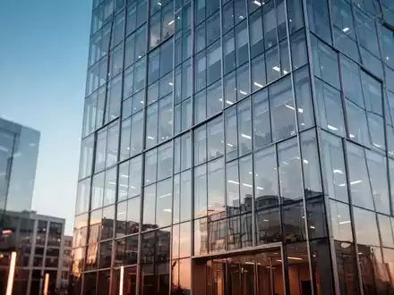 Moderne Glasfassade eines Bürogebäudes bei klarem Himmel als Symbol für Finanznachrichten. - Foto: über boerse-global.de