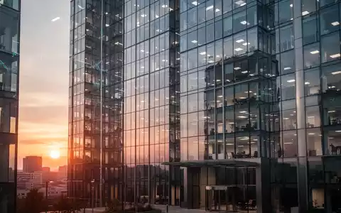Moderne Glasfassade eines Bürogebäudes bei Sonnenuntergang als Symbol für Finanzthemen. - Foto: über boerse-global.de