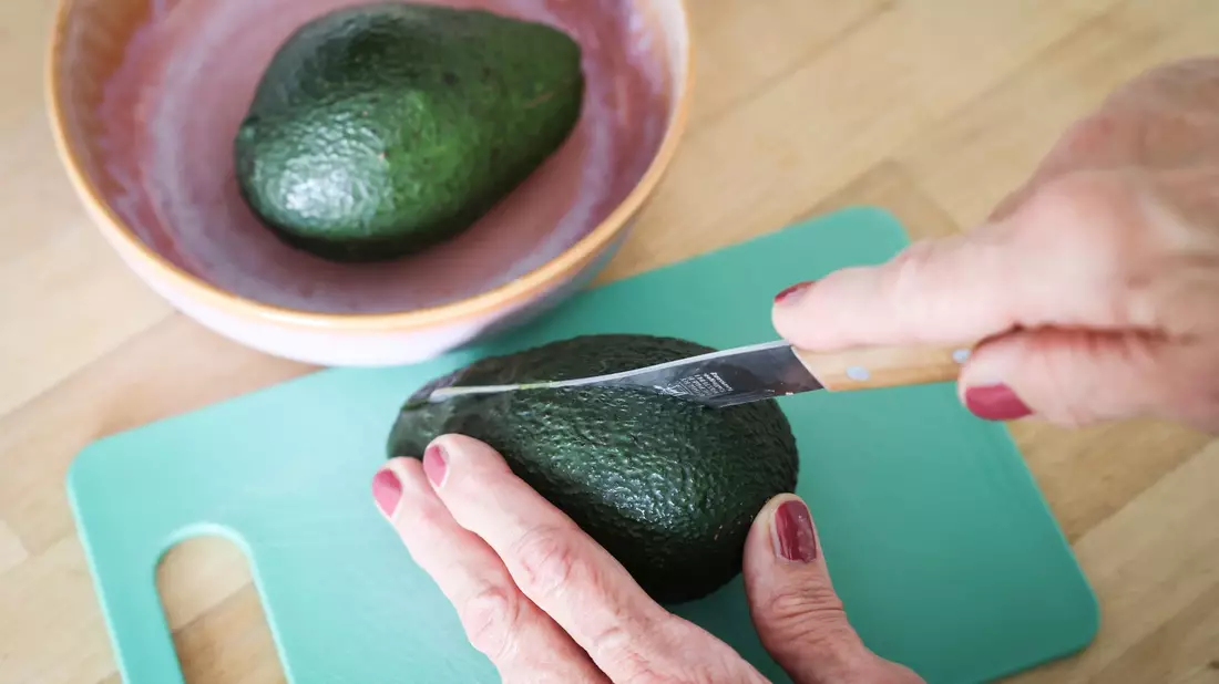 Die Avocado sollte beim Schneiden nicht in der Hand gehalten werden. - Bild: Christian Charisius/dpa