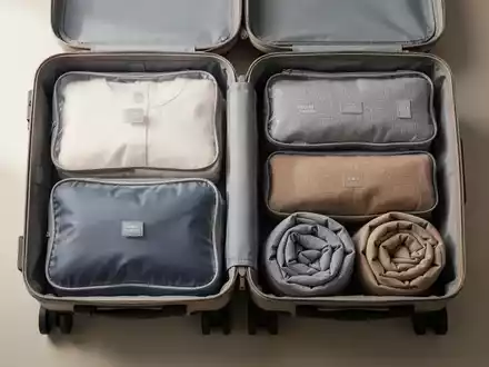 Ein ordentlich gepackter Reisekoffer mit gerollter Kleidung und Packwürfeln für minimalistisches Reisen. - Foto: über boerse-global.de