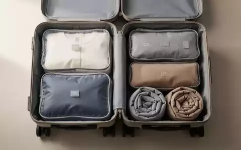 Ein ordentlich gepackter Reisekoffer mit gerollter Kleidung und Packwürfeln für minimalistisches Reisen. - Foto: über boerse-global.de