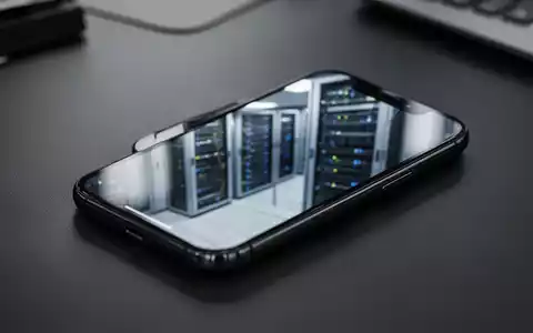 Ein Smartphone auf einem dunklen Schreibtisch vor dem unscharfen Hintergrund eines Serverraums. - Foto: über boerse-global.de