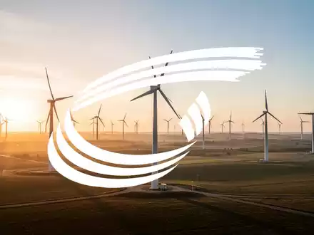 Moderne Windkraftanlagen in einer weiten, sonnigen Landschaft als Symbol für langfristige industrielle Finanzierung. - Foto: über boerse-global.de