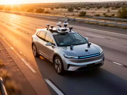 Ein autonomes Fahrzeug auf einer Autobahn bei Sonnenuntergang, ausgestattet mit Sensoren und Kameras zur Verkehrsüberwachung. - Foto: über boerse-global.de