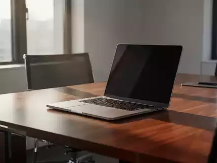 Ein moderner, minimalistischer Arbeitsplatz in einem Büro mit einem Laptop auf einem Holztisch bei natürlichem Tageslicht. - Foto: über boerse-global.de