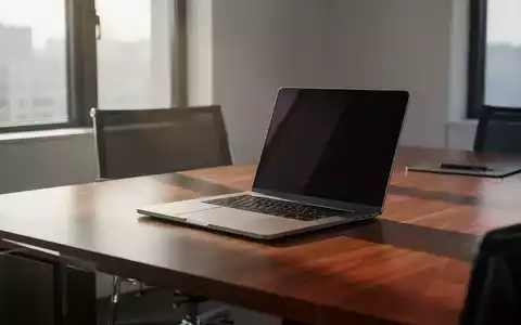Ein moderner, minimalistischer Arbeitsplatz in einem Büro mit einem Laptop auf einem Holztisch bei natürlichem Tageslicht. - Foto: über boerse-global.de