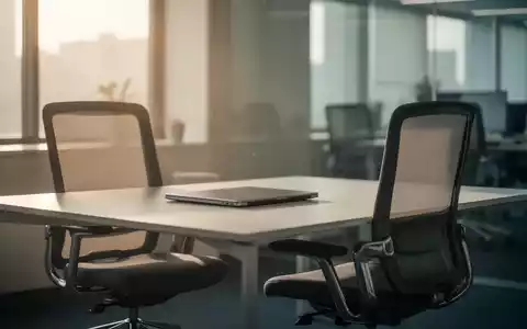 Ein leerer moderner Büroarbeitsplatz mit geschlossenem Laptop vor einem Fenster, das sanftes Tageslicht in den Raum lässt. - Foto: über boerse-global.de
