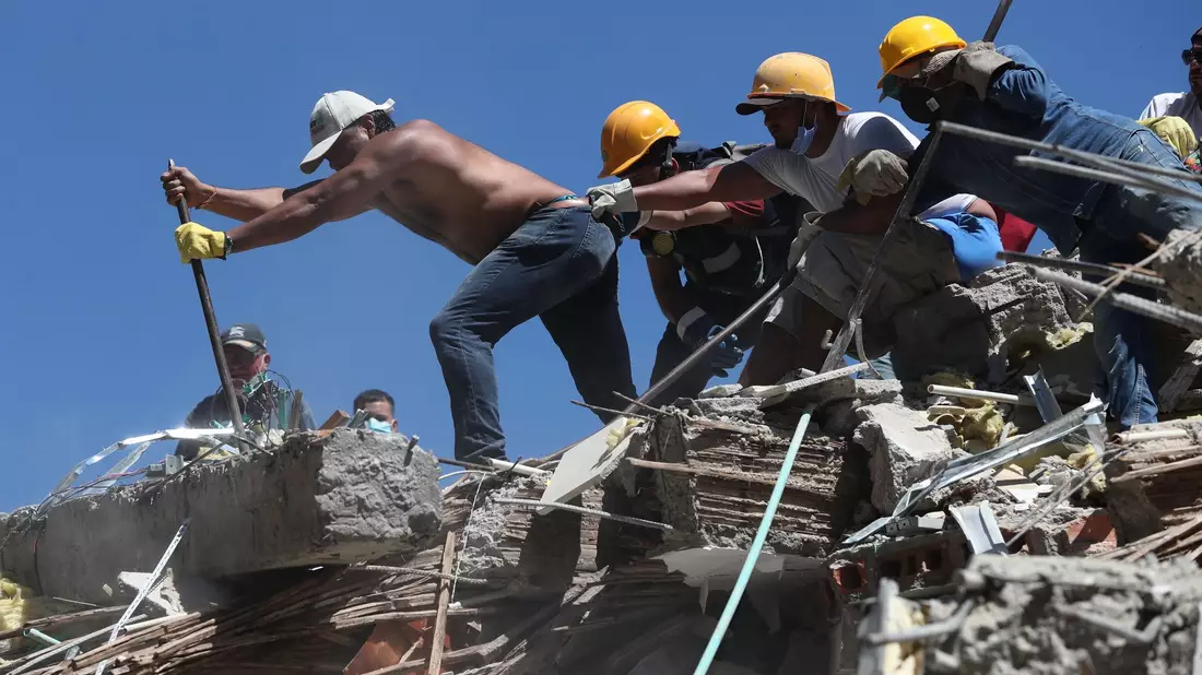 Rettungskräfte und Anwohner durchsuchen die Trümmer nach dem Erdbeben. - Bild: Santiago Saldarriaga/AP/dpa