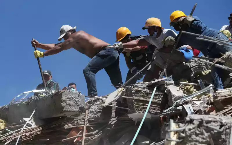 Rettungskräfte und Anwohner durchsuchen die Trümmer nach dem Erdbeben. - Foto: Santiago Saldarriaga/AP/dpa