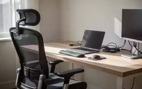 Ein aufgeräumter, ergonomisch gestalteter Arbeitsplatz mit modernem Bürostuhl und Schreibtisch bei natürlichem Tageslicht. - Foto: über boerse-global.de