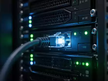 Dunkler Serverraum mit blinkenden blauen und grünen LED-Statusleuchten an Rack-Servern, die eine digitale Bedrohung symbolisieren. - Foto: über boerse-global.de