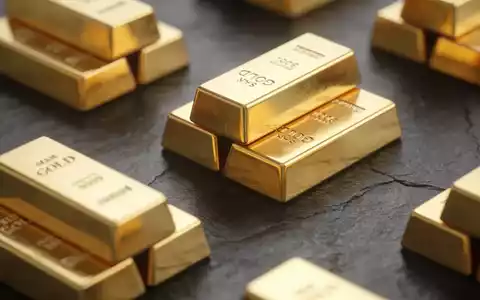 Mehrere glänzende Goldbarren liegen auf einer dunklen, texturierten Oberfläche. - Foto: über boerse-global.de