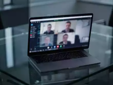 Ein Laptop-Bildschirm in einem modernem Büro, der eine Videokonferenz zeigt, als Symbol für digitale Sicherheitsrisiken. - Foto: über boerse-global.de
