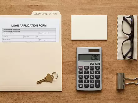 Flatlay-Arrangement rund um Kreditunterlagen zum Thema Deutsche Bank Kredit, ISIN DE0005140008, weiches Oberlicht - Foto: THN