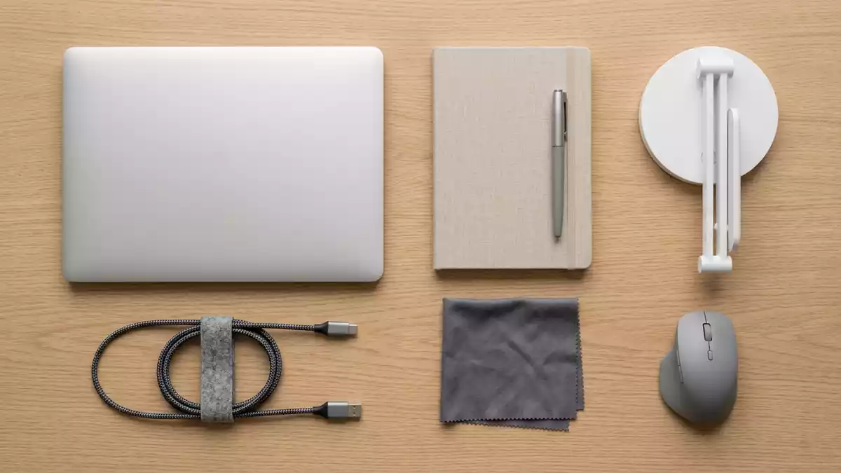 Flatlay-Arrangement rund um Laptop mit passenden Requisiten von oben, neutral