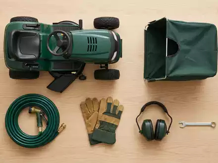Flatlay-Arrangement rund um Rasentraktor zum Thema John Deere Rasentraktor, ISIN US2441991054, weiches Oberlicht - Foto: THN