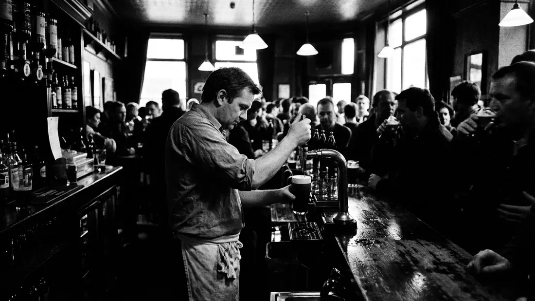 Schwarzweiss-Reportagebild mit Stoutbier in dokumentarischer Arbeitsumgebung, neutral