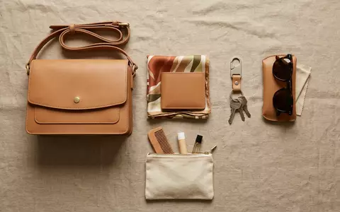 Flatlay-Arrangement rund um Lederhandtasche zum Thema Michael Kors Handtasche, ISIN US14040H1059, weiches Oberlicht - Foto: THN