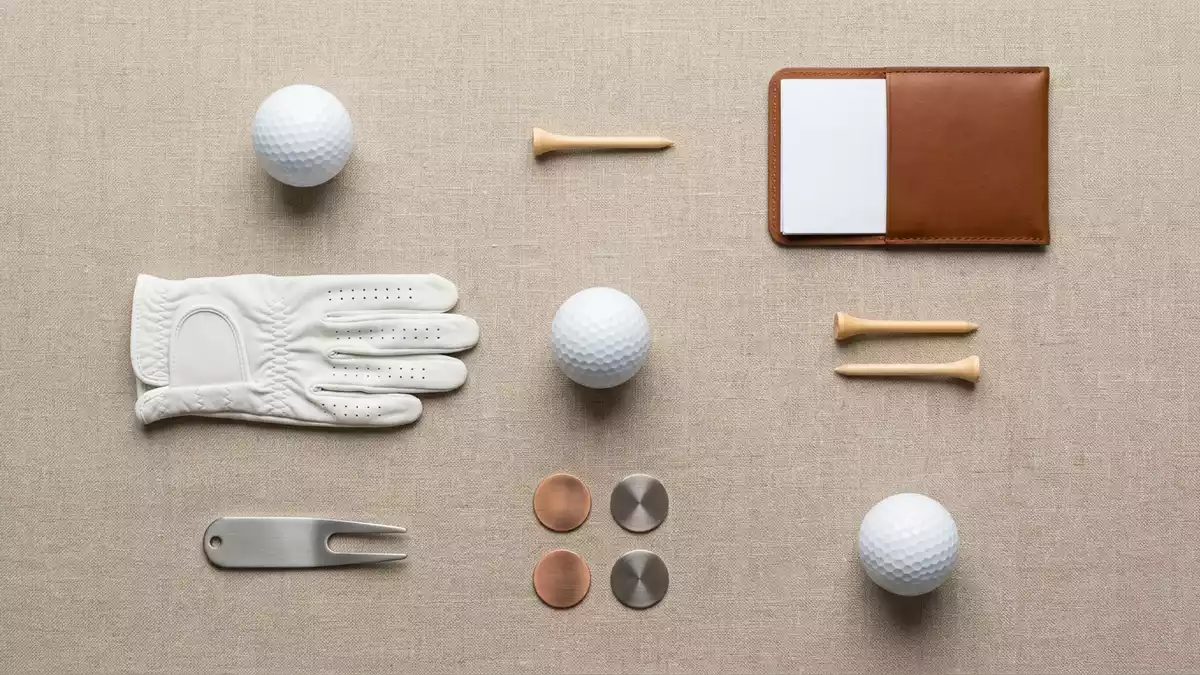 Flatlay-Arrangement rund um Golfball mit passenden Requisiten von oben, neutral