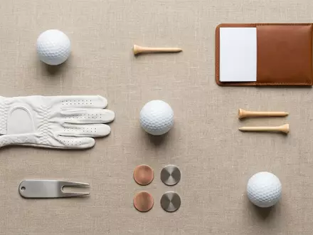 Flatlay-Arrangement rund um Golfball zum Thema Titleist Pro V1, ISIN US0050981085, weiches Oberlicht - Foto: THN