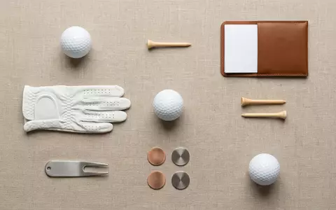 Flatlay-Arrangement rund um Golfball zum Thema Titleist Pro V1, ISIN US0050981085, weiches Oberlicht - Foto: THN