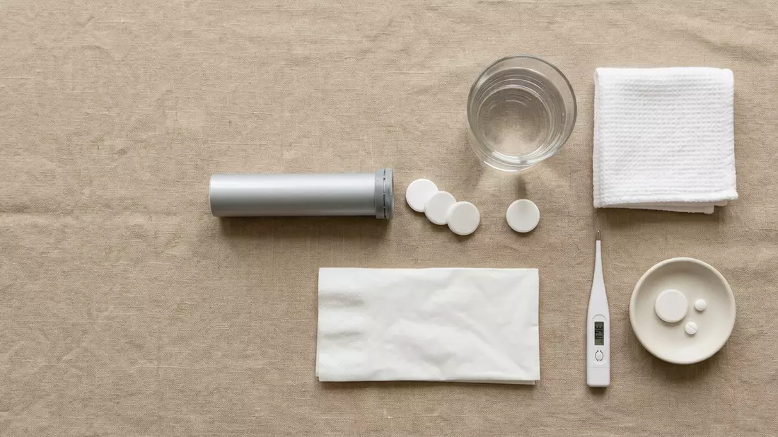 Flatlay-Arrangement rund um Erkältungstabletten mit passenden Requisiten von oben