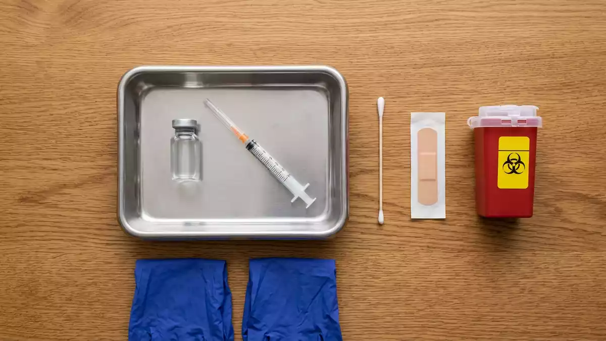 Flatlay-Arrangement rund um Impfstoff mit passenden Requisiten von oben, neutral