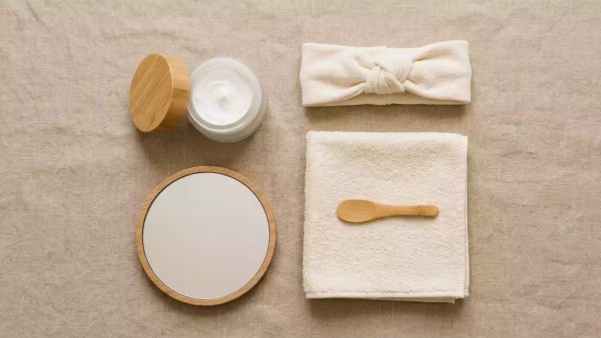 Flatlay-Arrangement rund um Gesichtscreme mit passenden Requisiten von oben, neutral